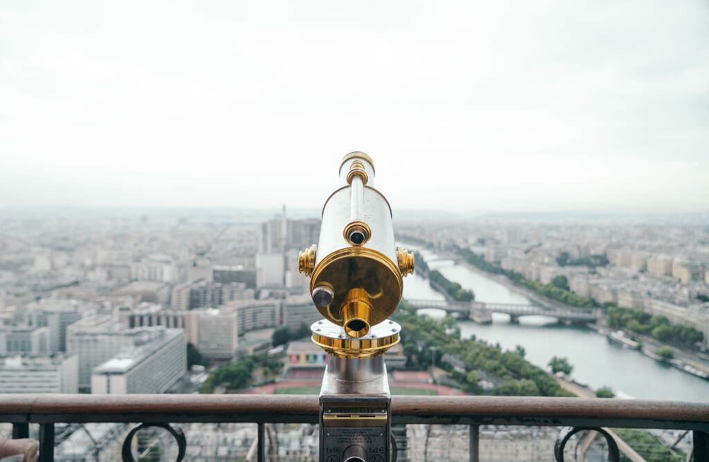 Gold and silver telescope overlooking a city view